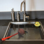 Overflowing,Kitchen,Sink,,Clogged,Drain.,Plunger,(force,Cup),And,Yellow