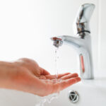 Hand,Under,Faucet,With,Water,Stream