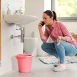 Woman,Calling,A,Professional,Plumber,At,Home,Using,Her,Smartphone,